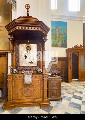 Kotor, Montenegro - 2. Juli 2024: Alte historische Innenstadt. St. Nikolaus Kirche Skulptur hölzerne Kanzel dekoriert mit Blumen und Bild des heiligen Stockfoto