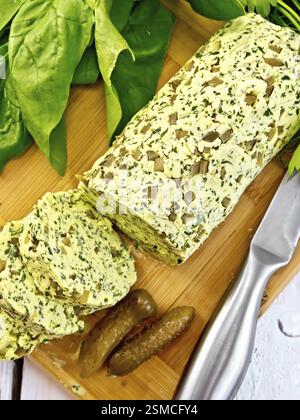 Butter mit Spinat, Gemüse, Ei und eingelegten Gurken auf einem Brett, Messer auf dem Hintergrund helle Holzbretter oben Stockfoto