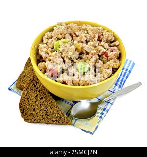 Brei Roggen Flocken mit kandierten Früchten in eine gelbe Schale, Roggenbrot, Löffel auf blaue Serviette isoliert auf weißem Hintergrund Stockfoto