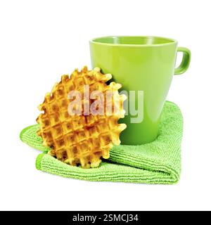 Runde goldene Waffel, einem grünen Becher auf die grüne Serviette isoliert auf weißem Hintergrund Stockfoto