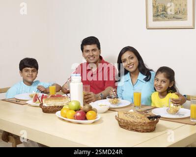 Eltern mit Kindern, die zum Frühstück auf dem Esstisch sitzen MR#702R, MR#702S, MR#702T, MR#702U Stockfoto