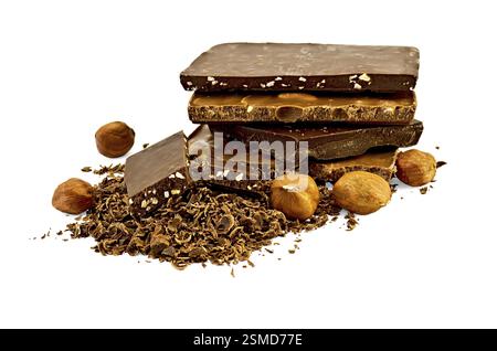 Ein Stapel verschiedene Pralinen, viel geriebene Schokolade mit zwei Scheiben Schokolade mit Nüssen, fünf Nusskerne Haselnüsse isoliert auf einem weißen Backgürtel Stockfoto