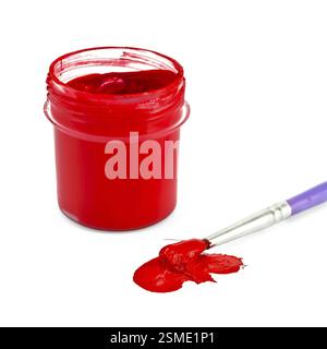 Glas mit roter Gouache, Pinsel und Fleck, isoliert auf weißem Hintergrund Stockfoto
