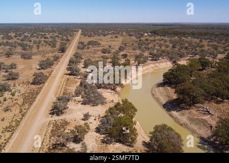 Ein weitläufiger Blick auf die Darling River Road East Side in der Nähe von Louth, New South Wales, Australien. Die Landschaft wird von einer unbefestigten Straße dominiert, die durch die Gegend führt Stockfoto
