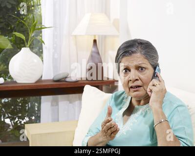 Alte Dame in Spannung hören auf mobile Herr #702S Stockfoto