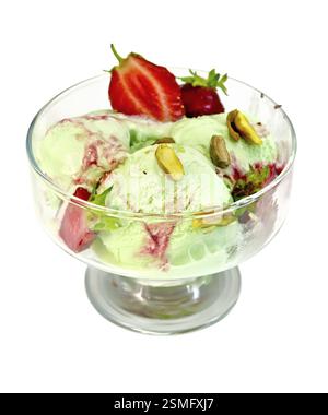 Eis Erdbeere und Pistazien in einem Glasbecher mit Erdbeeren und Pistazien isoliert auf weißem Hintergrund Stockfoto