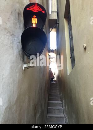 Verkehrsampel Tschechische Republik in einer engen Gasse mit Treppen. Rotes Licht leuchtet. Symbol für Fußgängerübergang sichtbar. Tschechische Republik Stockfoto