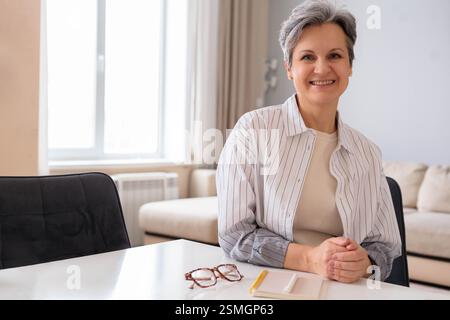 Porträt einer schönen, gepflegten Rentnerin im Alter. Ältere Dame mit grauem Haar sitzt Stockfoto