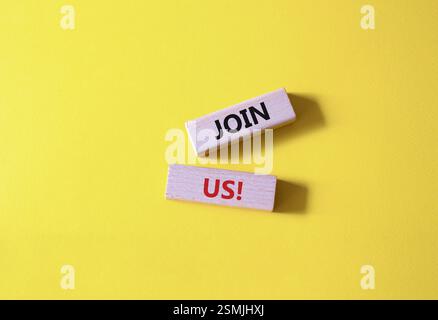 Schließen Sie sich uns an. Concept Word Kommen Sie uns auf Holzblöcken. Schöner gelber Hintergrund. Business und Join US-Konzept. Kopierbereich Stockfoto