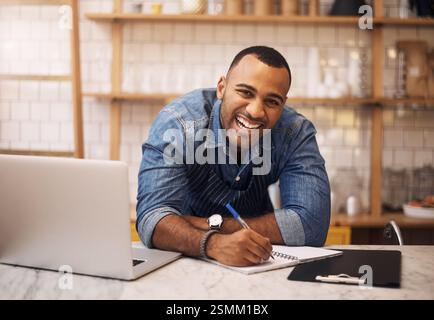 Kleine Unternehmen, Mann und Porträt mit Laptop für Café, Gastfreundschaft oder Bestellung mit Schreiben für Startup. Café-Bar, männlicher Barista und lacht mit Stockfoto