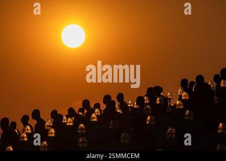 Bangkok, Thailand. Februar 2025. Mönche beten, wenn die Sonne während der jährlichen Zeremonie von Makha Bucha im Wat Dhammakaya im Norden von Bangkok untergeht. Die Thailänder feiern das buddhistische fest der Umgehungsbewegung im Uhrzeigersinn und die Makha Bucha Laternen-Lichtzeremonie am „Makha Bucha Day“ während des dritten Mondmondes, wo sich etwa 1250 Mönche versammelten, um vom Buddha geweiht zu werden, und 35000 Gläubige, die Laternen halten. Quelle: SOPA Images Limited/Alamy Live News Stockfoto