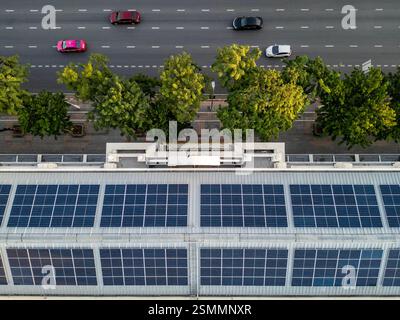 Draufsicht der blauen Solar-Photovoltaik-Anlage auf dem Dach des großen Industriegebäudes oder eines Lagers. Erneuerbares ökologisches Grün Stockfoto