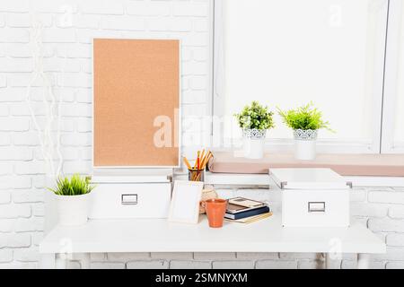 Modernes Design mit Korkbrett, Pflanzen und organisiertem Schreibpapier in einem hellen, minimalistischen Ambiente Stockfoto