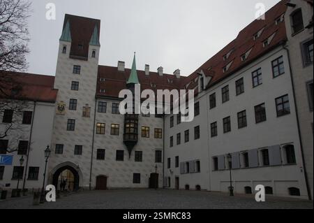 Ein großes weißes Gebäude mit einem roten Ziegeldach und einem Uhrenturm dominiert die Szene in Deutschland, München. Es ist ein Wahrzeichen Gebäude, wahrscheinlich das Alter Ho Stockfoto