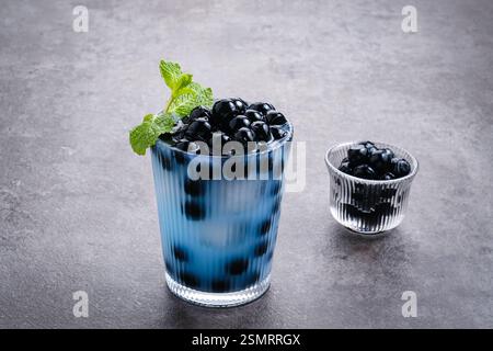 Schmetterlingserbsenmilch-Bubble-Tee mit boba-Tapioka-Perlen und Minzgarnitur Stockfoto