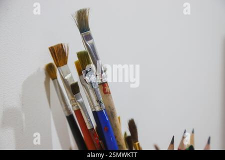 Eine Sammlung von Pinseln und Bleistiften ist im Atelier eines Künstlers ordentlich angeordnet und spiegelt die lebendigen Werkzeuge wider, die für den kreativen Ausdruck in der Kunst verwendet werden. Stockfoto