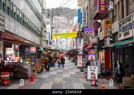 Busan, Südkorea - 24.03.2024: Berühmter Jagalchi Fish Market, Händler, die frische Meeresfrüchte und Muscheln verkaufen. Geschäftige Atmosphäre, traditionelle koreanische Kultur Stockfoto