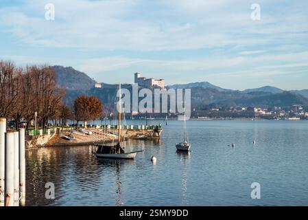 Arona, Lago Maggiore, Piemont, Italien: Die Stadt erwacht zu den frühen Morgenlichtern am Ufer des Sees, der von Winternebeln umhüllt ist. Stockfoto