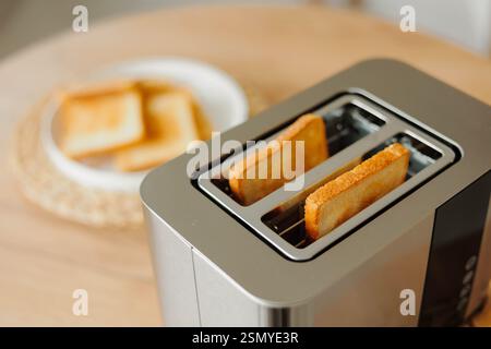 Zwei Stücke gebratenes goldenes Brot im Toaster. Morgenmahlzeit. Stockfoto