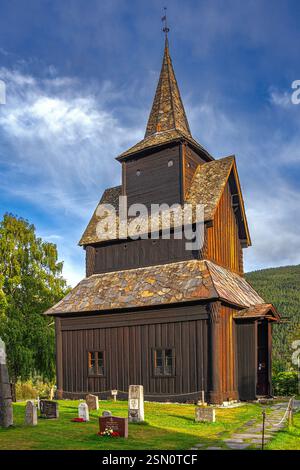 Weiße Holzkirche mit braunem Dach und Glockenturm neben einem alten Holzgebäude mit Friedhof. Torpo, Ål, Buskerud, Norwegen, Europa Stockfoto