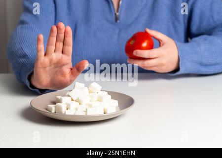 Frau auf Diät weigert sich, Zucker zu essen. Handschild, das Zucker in Lebensmitteln abstößt. Diabetes-Krankheitskonzept. 14. November. Stockfoto