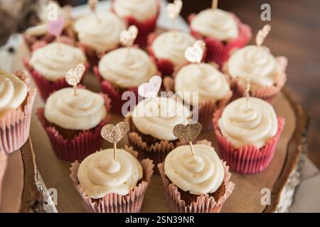 Hochzeits-Cupcakes, dekoriert mit Kerzen in Herzform. Schokoriegel für Hochzeiten. Stockfoto