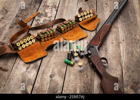 Schrotflinte und Munition auf einem rustikalen Holztisch, der die Vorbereitung eines Jägers auf einen Tag im Freien zeigt Stockfoto