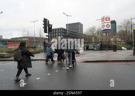 Menschen, die die Straße an einem Fußgängerübergang überqueren, auf dem Weg zur Euston Station in London Stockfoto