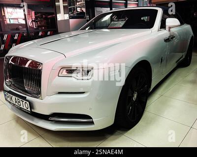 Lviv, Ukraine - 12. Februar 2025: Ein luxuriöses, weißes Cabriolet Rolls-Royce Dawn in einem Showroom mit elegantem Design. Stockfoto