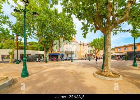 Straßencafés und Geschäfte am weitläufigen, von Bäumen gesäumten Platz des Lices und Park im historischen Zentrum von Saint-Tropez Frankreich, französische Riviera Stockfoto