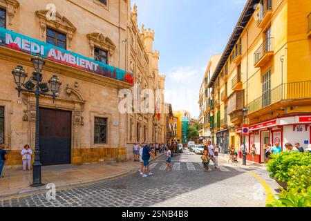 Touristen kommen am Rathaus auf dem historischen Marktplatz der spanischen Mittelmeerstadt Palma de Mallorca, Spanien, auf der Insel Mallorca vorbei Stockfoto
