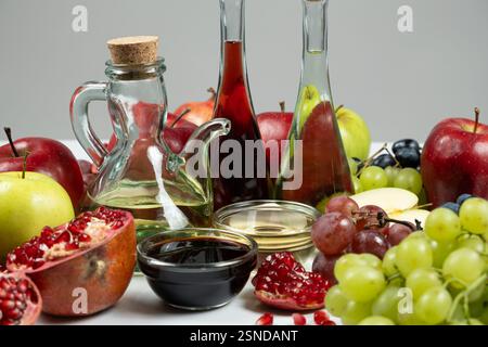 Verschiedene Arten von Essig Apfel, Wein und Granatapfel in Essigschalen unter Früchten. Stockfoto