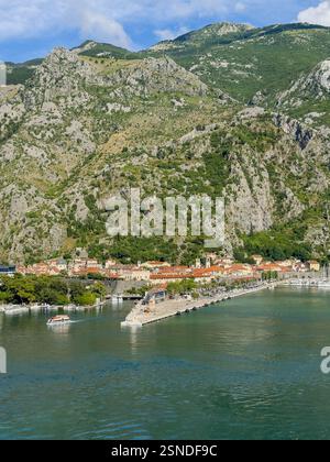 Kotor, Montenegro - 2. Juli 2024: Alte historische Innenstadt in Landschaft mit Hafen im Vorfeld und Berg mit Kirche und Schloss dahinter Stockfoto