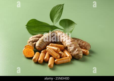 Kurkuma-Rhizome und -Kapseln auf grünem Hintergrund, Nahaufnahme Stockfoto