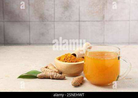 Aromatischer Kurkuma-Tee, Rhizome und Pulver auf weißem, strukturiertem Tisch Stockfoto