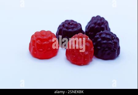 Eine Kollektion von roten und violetten beerenförmigen Bonbons, darunter anscheinend Himbeergeschmack oder gemischte Beerengeschmack. Diese Frucht-inspirierten Stockfoto