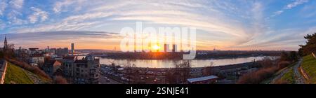 Atemberaubender Panoramablick auf die Skyline von Belgrad bei Sonnenuntergang mit Donau und bewölktem Himmel Stockfoto