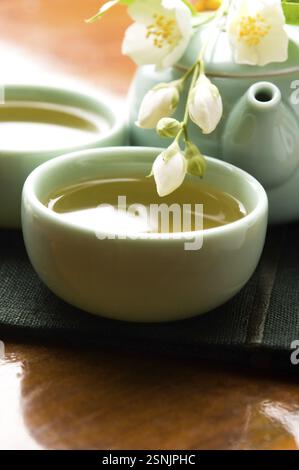 Grüner Tee mit Jasmin in der Tasse und Teekanne auf Holztisch, lodz, polen Stockfoto