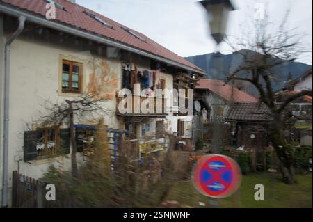 Ein Appartementgebäude in München, Deutschland, mit clothes晾 (liàng) Trocknung auf einem Balkon. Vor dem Gebäude steht ein Parkverbot. Die Szene sugg Stockfoto