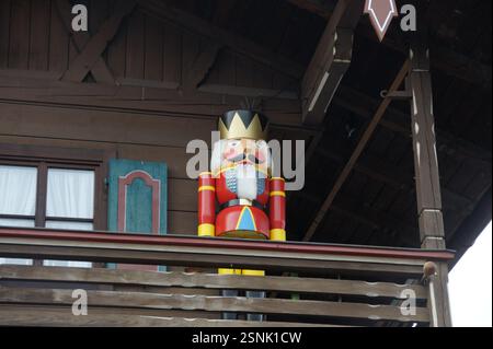 Ein großer hölzerner Nussknacker steht auf einem Balkon in München, Deutschland, und verleiht in den Sommermonaten eine festliche Note. Der dekorative Soldat schafft einen Stockfoto