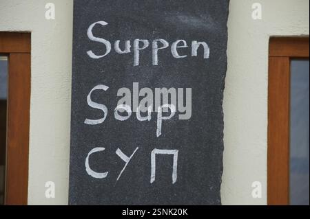 Ein Schild mit Tafel, das wahrscheinlich für ein Restaurant in Deutschland, München, steht für Suppe in deutscher und englischer Sprache. Dieses Schild, in zwei Sprachen geschrieben, könnte Stockfoto