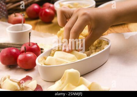 Detail von Kinderhänden, die Apfelkuchen herstellen, lodz, polen Stockfoto