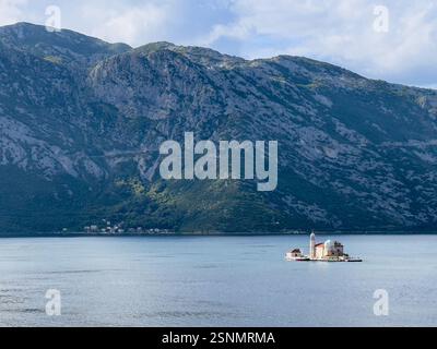 Bucht von Kotor, Montenegro - 2. Juli 2024: Insel Perast mit Kirche unserer Lieben Frau von Skrpjela. Weite Landschaft mit nordwestlicher Küstenlinie der Bucht Stockfoto