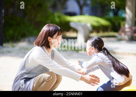 Lächelnde Kinderbetreuerin, die ein Kind umarmt Stockfoto