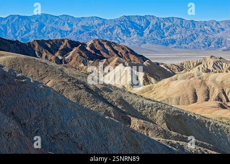 Mehrfarbige Hänge am Zabriskie Point mit entfernten Panamint Bergen Stockfoto