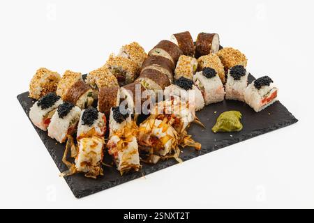 Eine wunderschön angeordnete Sushi-Platte zeigt eine Auswahl an Brötchen, darunter solche mit Kaviar und Sesamsamen, serviert mit Wasabi. Perfec Stockfoto