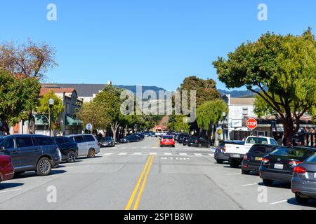 Eine ruhige Stage Road in einer bezaubernden Stadt, umgeben von üppigen Bäumen, Schaufensterfronten und einer malerischen Kulisse aus Hügeln - Half Moon Bay, Kalifornien, USA - 9. Februar Stockfoto