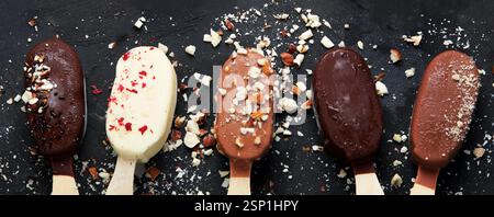 Eis-Sortiment auf dunklem Hintergrund. Natürlicher Hintergrund im Frühling. Draufsicht, flach Stockfoto