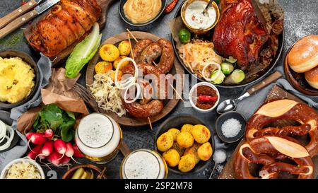 Deutsche Küche auf dunklem Hintergrund. Gegrilltes Fleisch und Snacks. Draufsicht, flach Stockfoto