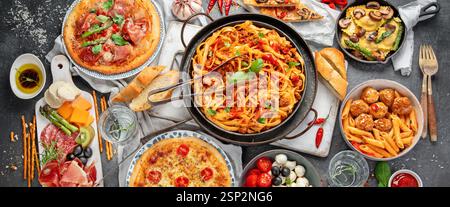 Italienisches Speisesortiment auf dunklem Hintergrund. Traditionelles kulinarisches Konzept. Gerichte und Vorspeisen. Draufsicht. Panorama. Stockfoto